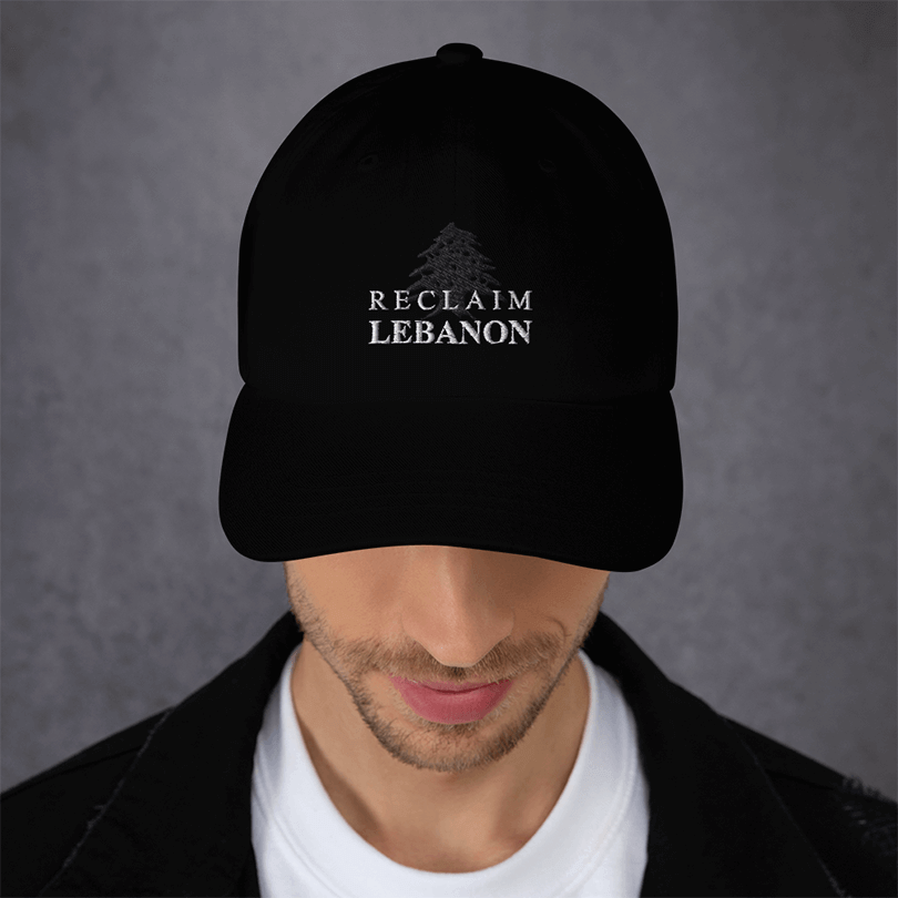 Black Cap with Reclaim Lebanon written on top of a dark grey stitch of the cedar